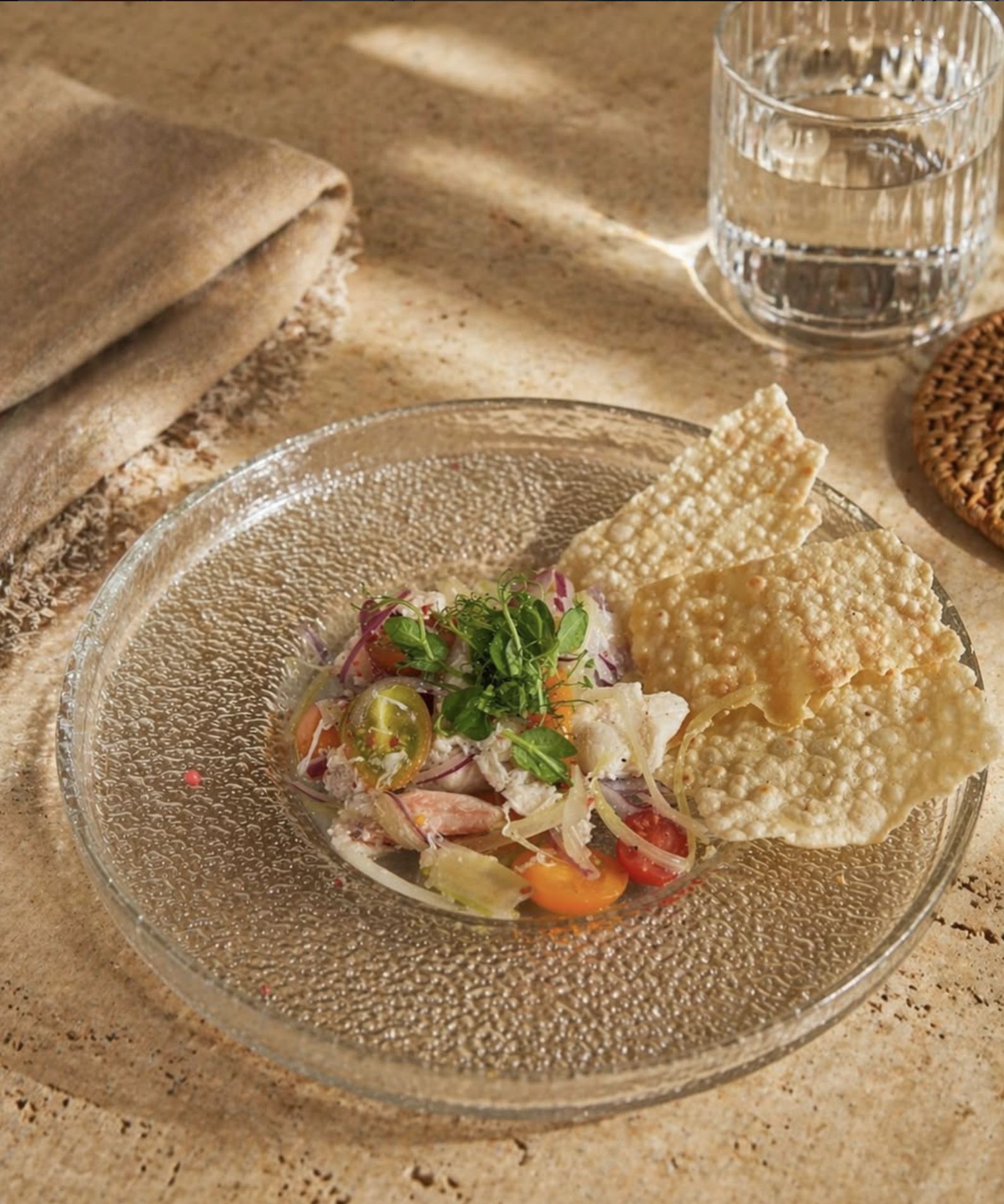 Crab salad with heirloom tomatoes and crisps on textured glass