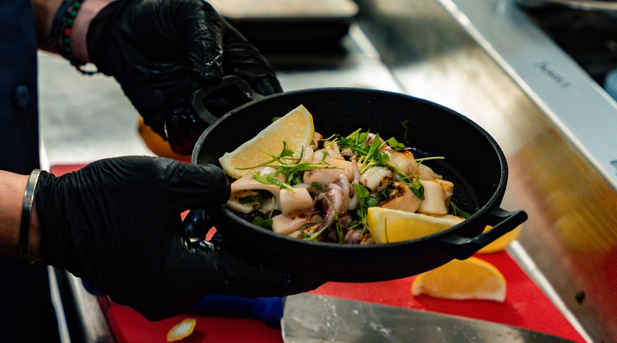 A chef plating octopus in the IKOS kitchen
